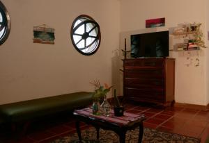 a living room with a couch and a tv and a table at Que onda! in Ubatuba