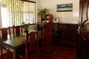 a dining room with a table and chairs and a dresser at Que onda! in Ubatuba