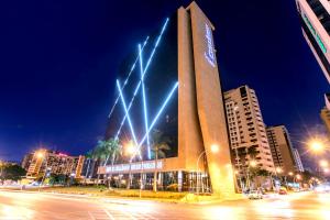 a building with lights on it in a city at night at Cullinan Hplus Premium in Brasilia