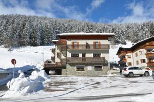 a large building with a balcony in the snow at Meublè Rosalpina in Valdidentro