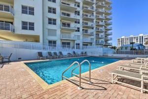 a swimming pool in front of a apartment building at Oceanfront Retreat with Pool Steps From Ormond Beach in Ormond Beach