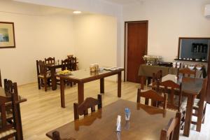 comedor con mesas y sillas y TV en Veneto Hotel, en Canguçu