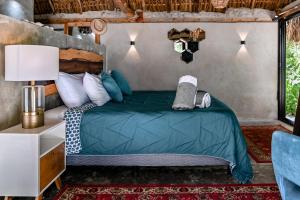 ein Schlafzimmer mit einem Bett mit grüner Bettdecke in der Unterkunft Casa Mate BeachFront Cabañas El Cuyo in El Cuyo