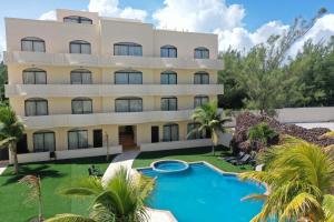 un immeuble d'appartements avec une piscine en face dans l'établissement Hotel Arenas del Mar Resort, à Tampico