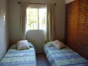 due letti in una stanza con una finestra di El Tilo a Colón