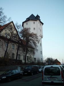 duży biały budynek z samochodami zaparkowanymi przed nim w obiekcie Ferienwohnung am KunstTurm w mieście Weimar