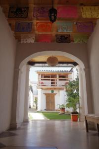 an archway leading to a house with colorful ceilings at Gaia Guest House in San Cristóbal de Las Casas