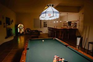 a living room with a pool table and a light at Hacienda del Avion in Bisbee