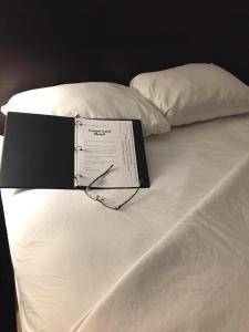 a book sitting on top of a white bed at Cougar Land Motel in Pullman
