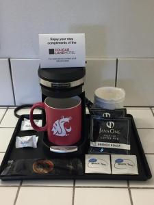 a tray with a coffee mug and other items on a counter at Cougar Land Motel in Pullman