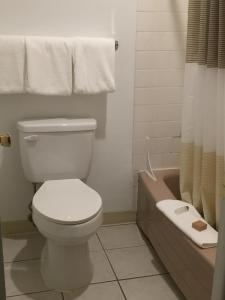 a bathroom with a toilet and a tub and a sink at Cougar Land Motel in Pullman