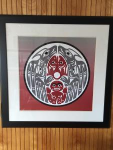 a framed painting of a mask on a wall at Cougar Land Motel in Pullman +3 photos