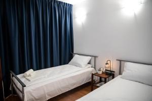 ein Schlafzimmer mit 2 Betten und einem blauen Vorhang in der Unterkunft Gran Gala in Baia Mare