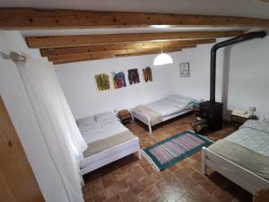 two beds in a room with wooden ceilings at VILA RIRA - Rrajcë, Shebenik in Përrenjas