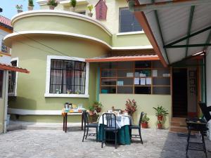 a table and chairs in front of a house at Posada Tambuca in Quito