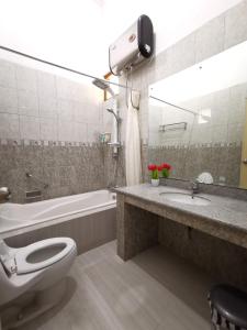 a bathroom with a toilet and a sink and a tub at Nariska Suite Homestay in Yogyakarta
