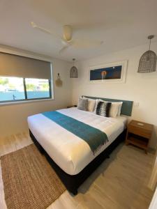 Un dormitorio con una cama grande y una ventana en Bay Royal Apartments, en Byron Bay