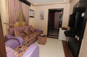 ein Wohnzimmer mit einem Sofa und einem TV in der Unterkunft مون تري للشقق المخدومة فرع الرياض in Riad