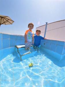two young boys standing in a swimming pool at Waves Surf Camp Peru in Punta Hermosa
