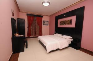 1 dormitorio con 1 cama grande y paredes rosas en مون تري للشقق المخدومة فرع الرياض, en Riad