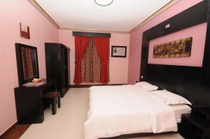 1 dormitorio con cama blanca y cortina roja en مون تري للشقق المخدومة فرع الرياض, en Riad