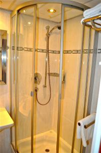 La salle de bains est pourvue d'une douche et d'une cabine de verre. dans l'établissement Savoy Hotel, à Francfort-sur-le-Main