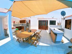 a patio with a wooden table and chairs on a house at Waves Surf Camp Peru in Punta Hermosa