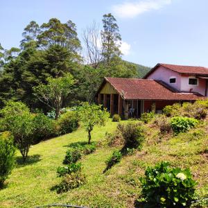 Sitio na Serra da Mantiqueira Águas do Canjarana في ساو فرنسيسكو كزافييه: منزل على جانب تل به أشجار