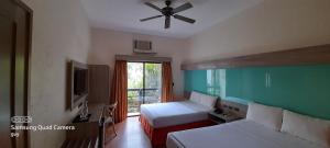 a bedroom with two beds and a ceiling fan at Microtel by Wyndham Boracay in Boracay