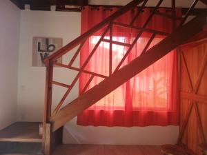 escalera en una habitación con cortina roja en Ibiza Tropical Beach Villas, en Uvita