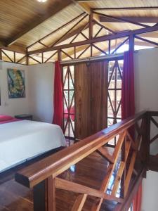 een slaapkamer met een bed en een houten trap bij Ibiza Tropical Beach Villas in Uvita