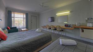 um quarto de hotel com uma cama, uma mesa e cadeiras em Alluna Motel em Armidale