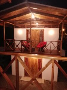 Cama en habitación con 2 sillas rojas en Ibiza Tropical Beach Villas, en Uvita