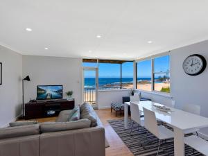 a living room with a couch and a table at Golden Sands 1 - Absolute Beachfront in Blue Bay 