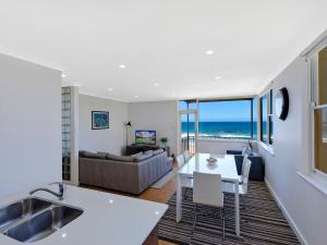 a kitchen and living room with a view of the ocean at Golden Sands 1 - Absolute Beachfront in Blue Bay 