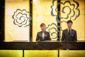 deux personnes en costumes assis à une table dans l'établissement Hangzhou Tower Hotel, à Hangzhou