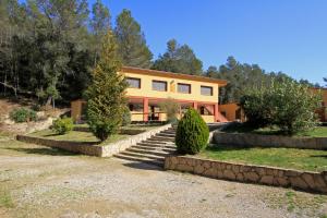 a large yellow house with stairs in front of it at El Xalió in Sant Miquel de Campmajor