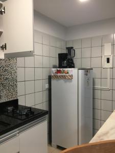 a kitchen with a refrigerator and a stove at Chales Adria in Porto De Galinhas