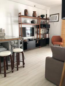 a living room with a table and chairs and a tv at Ipanema beach - Show de apart in Rio de Janeiro