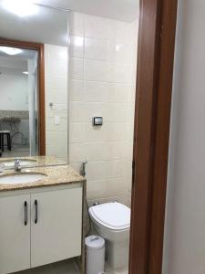 uma casa de banho com um WC, um lavatório e um espelho. em Ipanema beach - Show de apart no Rio de Janeiro