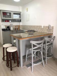 a kitchen with a counter and stools in a kitchen at Ipanema beach - Show de apart in Rio de Janeiro