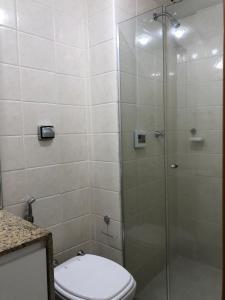 uma casa de banho com uma cabina de duche em vidro e um WC. em Ipanema beach - Show de apart no Rio de Janeiro