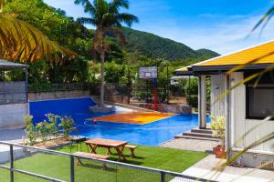 a backyard with a basketball hoop and a pool at Regina Ishigaki Kabira Sky / Two-Bedroom House in Kabira