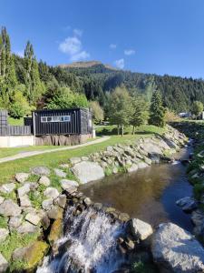 a river with a waterfall in a field at Qbox in Queenstown