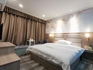 ein Schlafzimmer mit einem großen Bett in einem Zimmer in der Unterkunft Jieyang Yunduo Hotel (Chaoshan Airport) in Jieyang