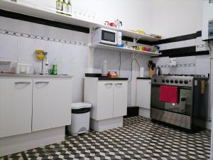a kitchen with white cabinets and a checkered floor at Casa Capilla in Valparaíso +13 photos