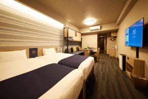 um quarto de hotel com duas camas e uma televisão de ecrã plano em MONday Apart Premium AKIHABARA ASAKUSABASHI Sta. em Tóquio