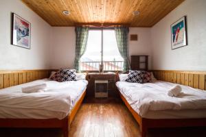 um quarto com duas camas e uma janela em Pension Fullnote em Niseko