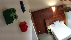 Un pequeño dormitorio con una cama y un pequeño armario en Departamento Casa Lego en Dina Huapi