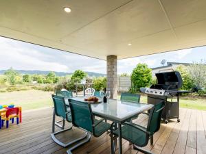 a patio with a table and chairs and a grill at Millies Place - Mangawhai Holiday Home in Mangawhai